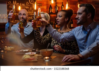 Group Of Friends Watching Tv In A Cafe Behind Bar Counter