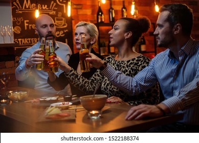 Group Of Friends Watching Tv In A Cafe Behind Bar Counter