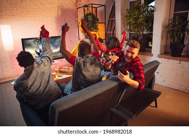 Group of friends watching TV, sport match together. Emotional man with phone cheering for favourite team, celebrating successful betting. Concept of friendship, leisure activity, emotions, finance.