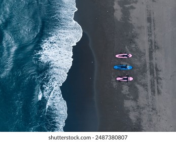 Group of friends in wetsuit going to surf at black beach, aerial top view Kamchatka Russia. Friendship adventure travel sport concept. - Powered by Shutterstock