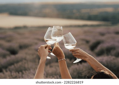 Group of friends with white wine in hands clinking with glasses. Close-up of hands and drinks. Beautiful scenic landscape.	
 - Powered by Shutterstock