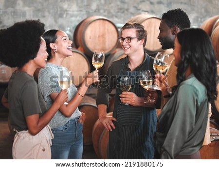 Group of friends wine tasting at a distillery or cellar drinking glasses and enjoying the tour together. Happy, carefree and diverse people bonding and having fun at a winery estate