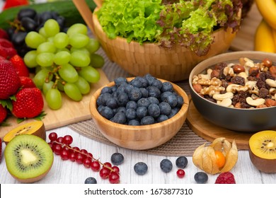 Group Fruits Breakfast mixed vegetables with salad bowl, nuts bowl, strawberry, banana, and pineapple, orange juice,  vitamin c in food  nature for health and diet in the top view on the wood table. - Shutterstock ID 1673877310