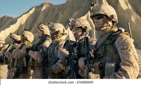 Group of Fully Equipped Soldiers Standing in a Line in the Desert.