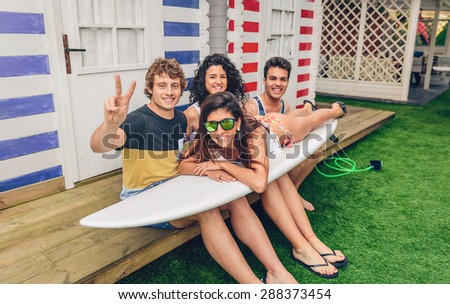 Similar – Young friends holding woman on top of surfboard