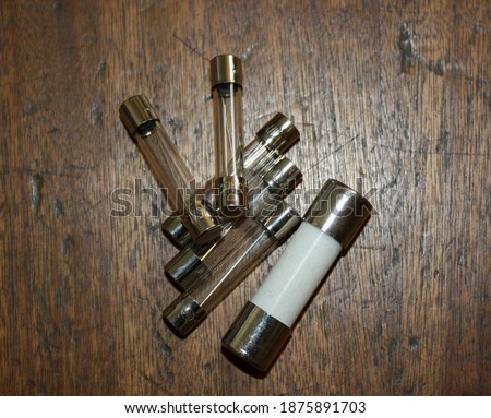 Group of fuses of different sizes on a weathered wooden surface.