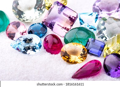 Group of gemstones on white sand with studio lighting.