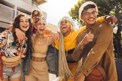 Group Of Generation Z Friends Laughing Together Outdoors. Cheerful Young Friends Embracing Each Other In The Summer Sun. Youngsters Having Fun And Enjoying Their Youth.