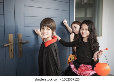 Group Of Girl And Boy Kids Smiling And Dress Up As Halloween Vampire Costume And Knock On Door For Trick Or Treat For Halloween Night Day Theme Coming Soon Together