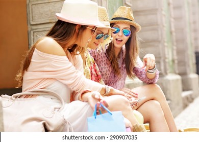 Group Of Girl Friends Resting After Shopping In The City