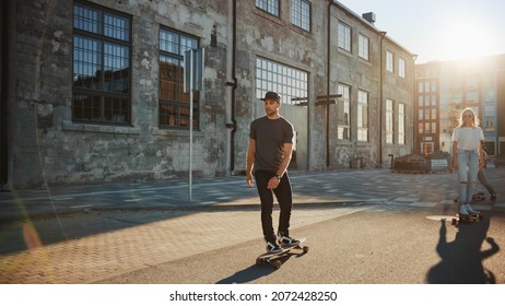 Group of Girls and Boys on Skateboards Through Fashionable Hipster District. Beautiful Young People Skateboarding Through Modern Stylish City Street During Golden Hour. - Powered by Shutterstock