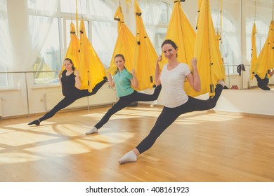 Group Of Girls Doing Fly Yoga In Hammocks