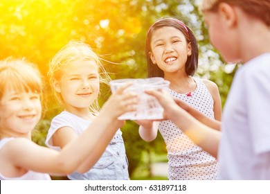 Group Of Girls Drinking Water In Summer As Friends At Childrens Birthday Party