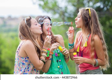 group of girls friends blowing bubbles at music festival - Powered by Shutterstock