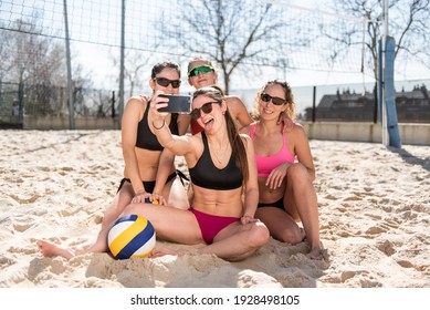 Group Of Girls Sitting On The Sand Taking A Photo. Girls Taking A Selfie. Volleyball Game.