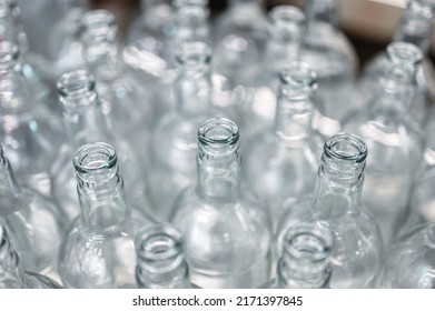 Group Of Glass Bottles For Alcohol Drink On Shiny Metal Table At Bright Light In Production Plant Workshop Extreme Closeup