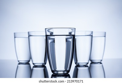 Group Of Glasses Filled With Water On White Background