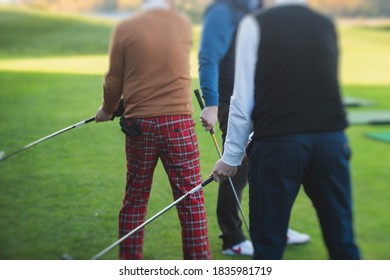 Group Of Golfers Practicing And Training Golf Swing On Driving Range Practice, Men Playing On Golf Course, Golf Ball At Golfing Complex Club Resort 