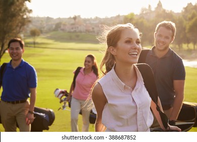 Group Of Golfers Walking Along Fairway Carrying Golf Bags - Powered by Shutterstock