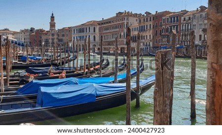 Group of gondolas moored in channel Canal Grande with scenic view of famous Rialto bridge in city of Venice, Veneto, Northern Italy, Europe. Venetian architectural landmarks. Romantic vacation