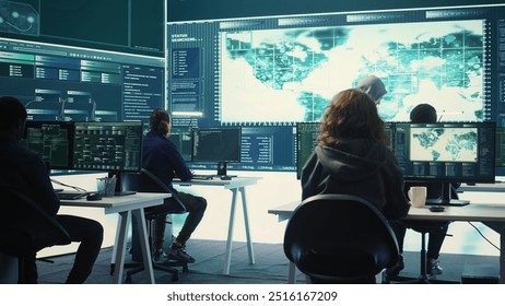 Group of governmental hackers using hacking tools to secure a network, focusing on cyber defense and data protection measures. Experts team examining important information on big screen. Camera B.
