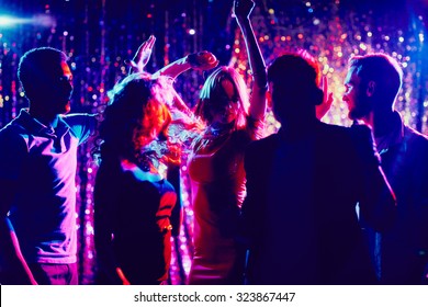 Group of guys and girls dancing in the night club - Shutterstock ID 323867447