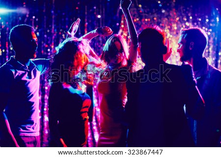 Group of guys and girls dancing in the night club