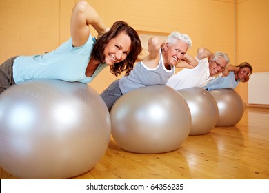 Group In Gym Doing Back Exercises On Swiss Balls