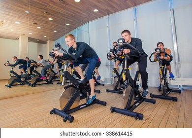 Group Of Gym People On Machines, Cycling In Class.