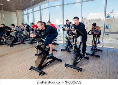 Group Of Gym People On Machines, Cycling In Class.