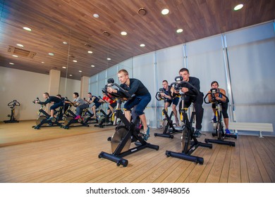 Group Of Gym People On Machines, Cycling In Class.