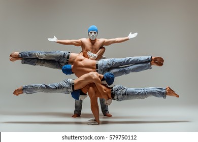 The group of gymnastic acrobatic caucasian men on balance pose