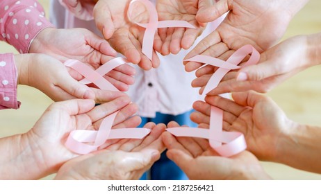 Group of woman’s hand holding pink ribbon for October breast cancer awareness month - Powered by Shutterstock