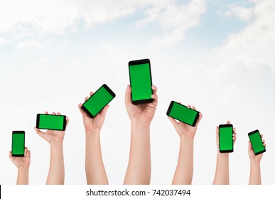 Group Of  Hands Holding Phones And Rising Them Up 