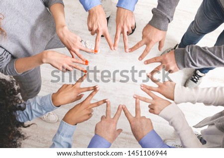 Group of hands showing peace hand sign, connecting fingers like star, top view
