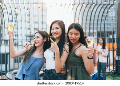 Group of happy Asian girl friends celebrating party with champagne glasses in sunset together, female gang chatting, laughing on smile face, night lifestyle of young people - Powered by Shutterstock