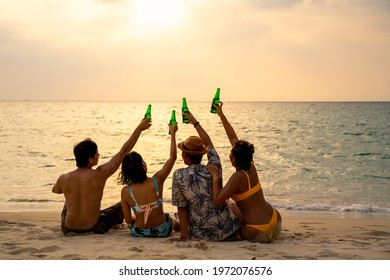 Group of Happy Asian man and woman friends sitting on the beach enjoy drinking beer with talking together at summer sunset. Male and female friendship relax and having fun outdoor lifestyle activity. - Powered by Shutterstock