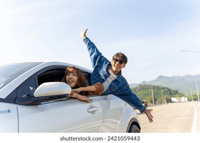 Group of Happy Asian man and woman enjoy and fun outdoor lifestyle road trip travel on summer holiday vacation. Generation z people friends sitting in the car looking beautiful nature of countryside. - Powered by Shutterstock