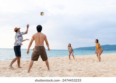 Group of Happy Asian man and woman enjoy and fun outdoor lifestyle travel at the sea on summer holiday vacation. People friends playing beach volleyball together on tropical island beach at sunset. - Powered by Shutterstock