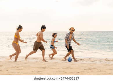 Group of Happy Asian man and woman enjoy and fun outdoor lifestyle travel at the sea on summer beach holiday vacation. People friends playing ball together on tropical island beach at sunset. - Powered by Shutterstock