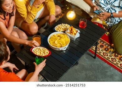 Group of Happy Asian millennial people friends enjoy dinner party with eating snack potato chip and soft drink at outdoor rooftop for meeting reunion celebration holiday event new year with happiness  - Powered by Shutterstock