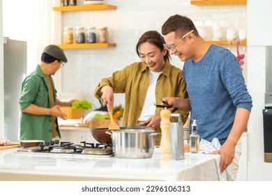 Group of Happy Asian people cooking healthy food pasta and salad for celebration dinner party together in the kitchen. Cheerful man and woman friends have fun reunion meeting event on holiday vacation - Powered by Shutterstock