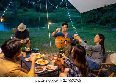 Group of Happy Asian people enjoy and fun outdoor lifestyle travel nature hiking and camping on summer holiday vacation. Man and woman friends cooking food and having dinner together at camp at night. - Powered by Shutterstock