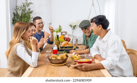 Group of Happy Asian people enjoy and fun celebration dinner party sharing and eating food with drinking wine together at home. Cheerful man and woman friends reunion meeting event on holiday vacation - Powered by Shutterstock