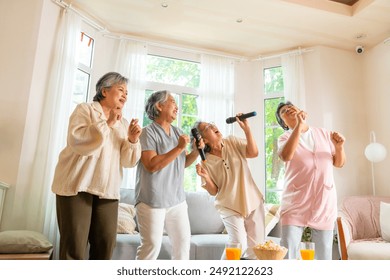 Group of Happy Asian senior women friends singing karaoke with dancing together in living room. Elderly retired people enjoy and fun indoor lifestyle spending time together with home entertainment. - Powered by Shutterstock