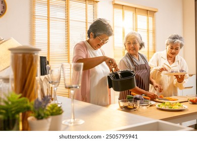 Group of Happy Asian senior women having dinner together at home. Elderly woman friends enjoy healthy lifestyle cooking and making vegan food vegetables salad with using air fryer in the kitchen. - Powered by Shutterstock