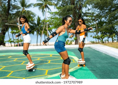 Group Of Happy Asian Woman Friends Skateboarding Together At Skateboard Park By The Beach. Happy Female Friendship Enjoy Summer Outdoor Active Lifestyle Play Extreme Sport Surf Skate At Public Park.