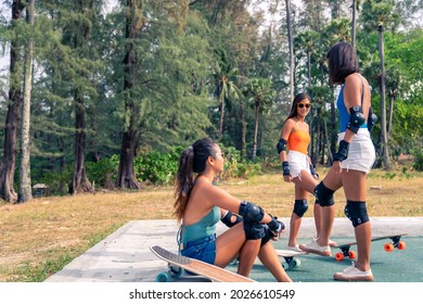 Group Of Happy Asian Woman Friends Skateboarding Together At Skateboard Park By The Beach. Happy Female Friendship Enjoy Summer Outdoor Active Lifestyle Play Extreme Sport Surf Skate At Public Park.