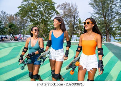 Group Of Happy Asian Woman Girl Friends Carry Skateboard Walking With Talking Together At Skateboard Park. Female Friendship Enjoy Outdoor Activity Lifestyle Play Extreme Sport Surf Skate Together