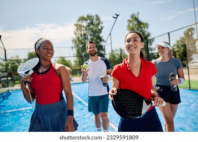 Group of happy athletes going for an outdoor mixed doubles match in paddle tennis. - Powered by Shutterstock